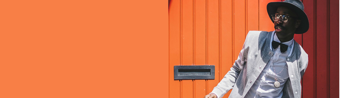 Modelo feminina vestindo blusa rosa fluorescente, em fundo lilás.