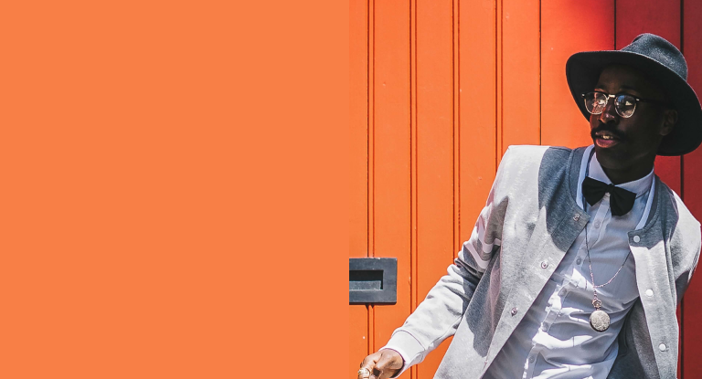 Modelo feminina vestindo blusa rosa fluorescente, em fundo lilás.